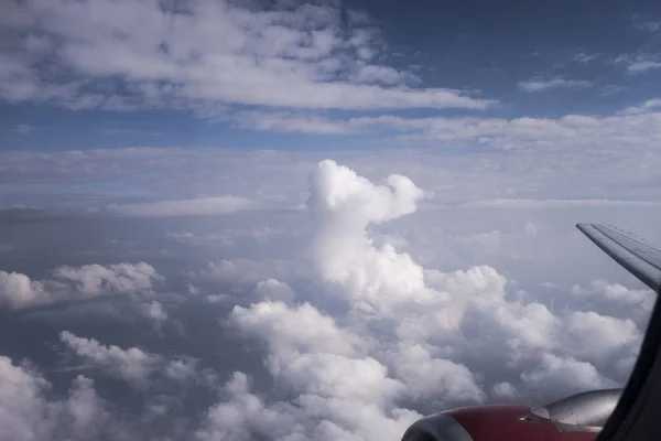 Looking out the window of an airplane above the cumulonimbus clo — Stock Photo, Image