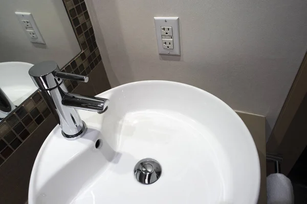  bathroom sink tile and faucet with white electric outlet on wall
