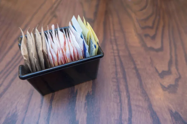 Şeker torbası tatlandırıcıları ile küçük siyah tepsi 