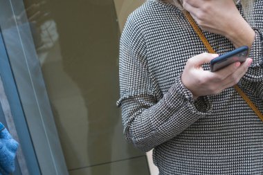 bir pencerenin üst bir cep telefonu kullanarak genç kadın