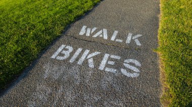 yeşil çim yürüyüş bisikletleri ile asfalt geçit sidew boyalı