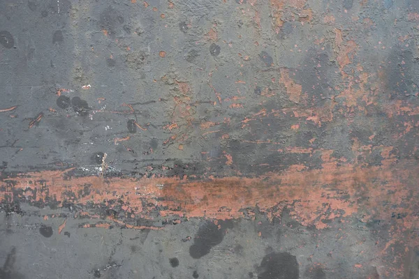 red orange painted weathered surface with flaking paint chips