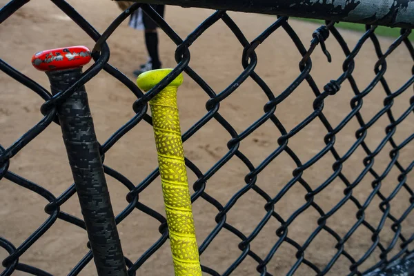 Bastões de beisebol / softball em uma cerca de rebatidas — Fotografia de Stock