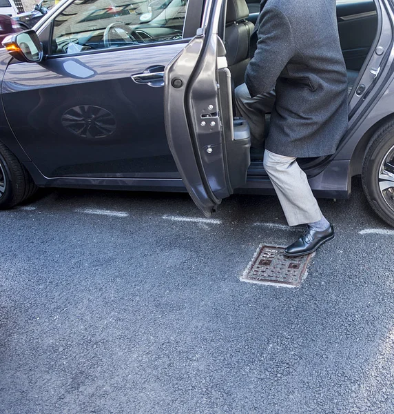 Homem entrando ou saindo do banco de trás de um carro de 4 portas em — Fotografia de Stock