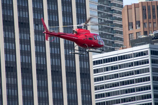 Red helicopter at sky scraper level in New York — Stock Photo, Image