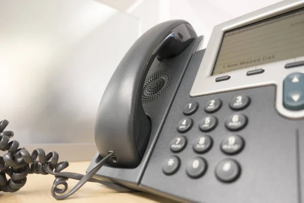 Graues Bürotelefon auf dem Schreibtisch — Stockfoto