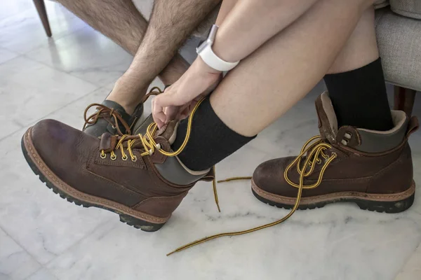 Hommes jambes avec des chaussures de bateau et la femme de mettre des bottes mains en mo — Photo