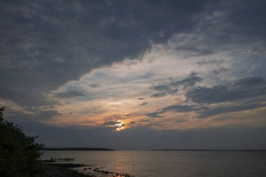 Güzel okyanus gökyüzü mavi turuncu gün doğumu kara bulutların ardında gün batımı