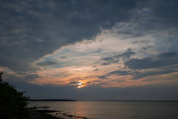 Beautiful ocean sky blue yellow orange sunrise sunset behind dark clouds