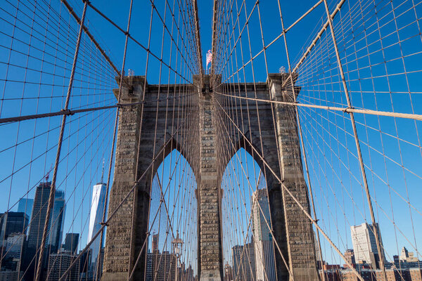 Close up brownstone Brooklyn bridge. Manhattan skyline view from the bridge