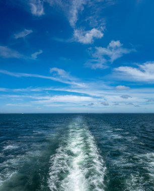 Büyük suyu olan sürat teknesi mavi gökyüzünde ve okyanus sularında uyanıyor.