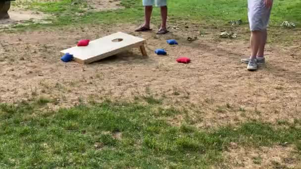 Menschen Die Das Maisloch Spiel Mit Roten Und Blauen Werfen — Stockvideo