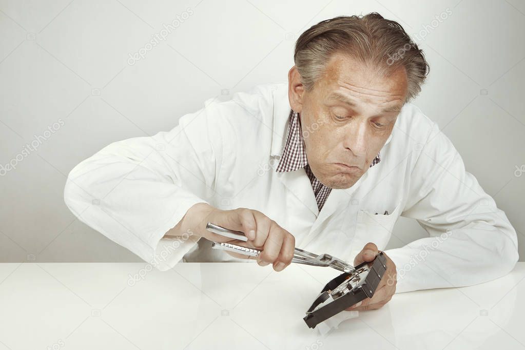 Hard disc drive specialist erasing data from hard disc drive with pliers