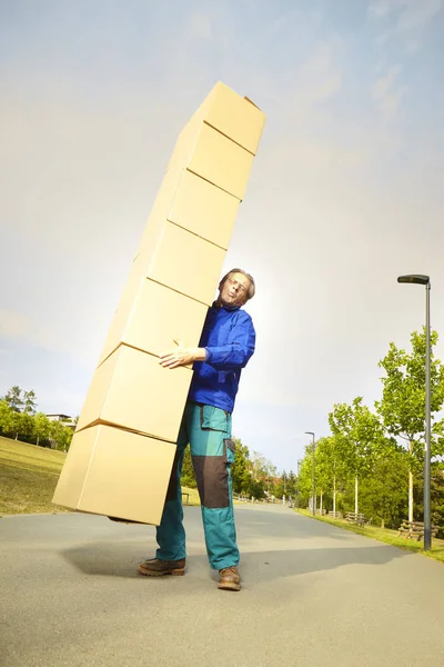 Man trying to catch falling several boxes of goods on way in city park