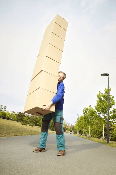 都市公園における途中の商品のいくつかの箱を運ぶ男 — ストック写真
