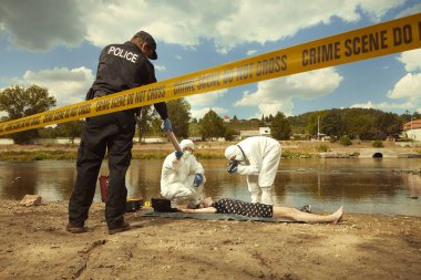Woman body in black apparel found drowned near summer river bank in city clipart