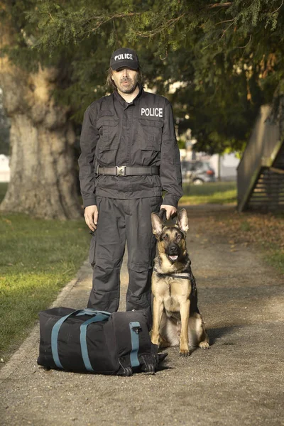 Politieagent Met Zijn Hond Controleren Onbekende Potentieel Gevaarlijke Tas Park — Stockfoto