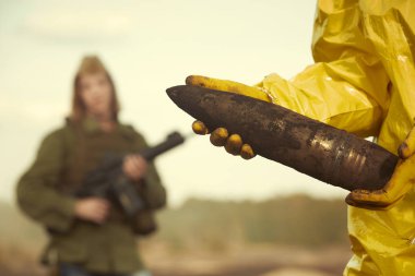 Sahada tehlikeli topçu el bombası elinde kimyasal koruyucu elbise uzmanı