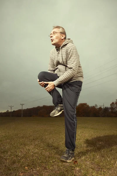 高齢老人 Sportsuit 草原に屋外で運動 — ストック写真