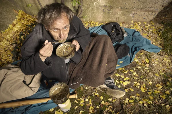 醜い乞食男生活屋外準備とレンズ豆のスープを食べる — ストック写真