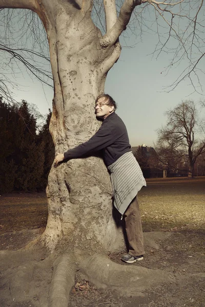 Man in ugly style dress charging his energy with trees in park