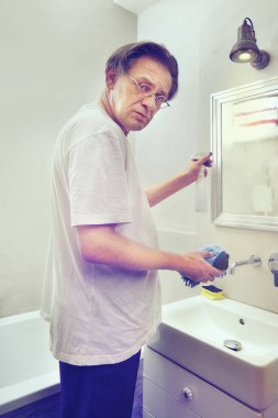 Eski zavallı adam evinin süpürge ve sünger ile Temizleme