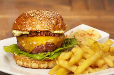 Lüks sığır eti burger peynir, pastırma marmelade, marul, patates kızartması ve salata salata ile topuz