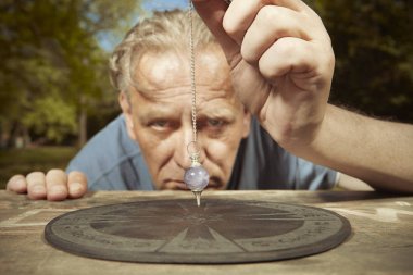 Yaz parkında yaşlı adam sarkaç ve masa ile hayaletler ile ruhsal bağlantı pratik