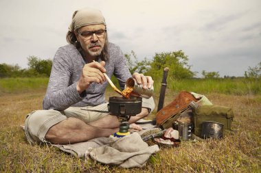 Yaz vahşi doğada gezide Olgun adam yiyecek hazırlanıyor