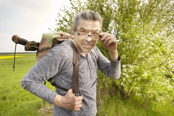 Mature man on trip in summer wilderness enjoying freedom