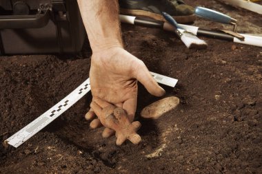 Arkeolojik alandaki nadir adak nesneleri bulduğunu gösteren gururlu kaşif