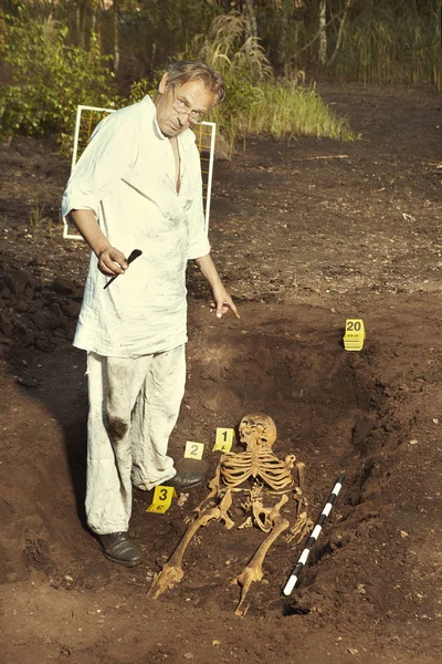 Archaeologist on outdoor location exploring ancient grave