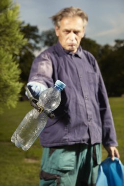 Kamu hizmetinde adam şehir parkında çöp temizleme