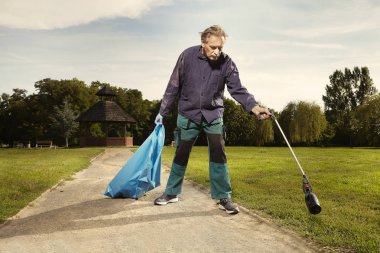 Kamu hizmetinde adam şehir parkında çöp temizleme