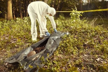 Gözlem için polis teknisyeni tarafından plastik ceset torbasına insan kalıntıları toplama