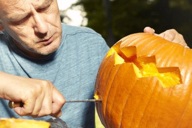 Yaşlı adam yaklaşan tatil olay için helloween kabak oyma