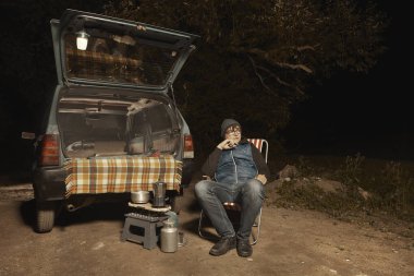 Seyahat adam onun arabada gece geçirmek için rota yakınında durur