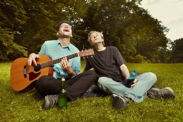 Dwóch Mężczyzn Miejskim Parku Letniej Łące Korzystających Dzień Gitary — Zdjęcie stockowe