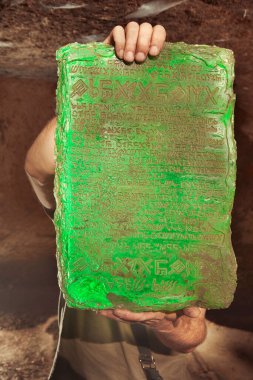 Mağarada maceracı tarafından bulunan gizemli zümrüt tabletinin ayrıntıları.