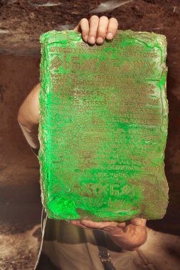 Detail of mysterious artifact emerald tablet found by adventurer in cave clipart