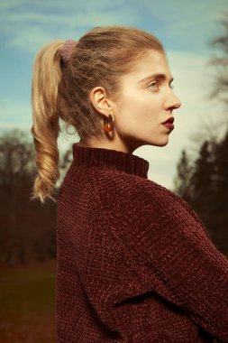 Kış portresi için sonbahar parkında poz veren hoş bayan.