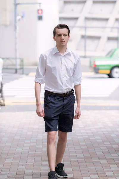 Young handsome French man walking in the Streets of Tokyo