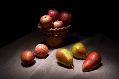 Elmalar ve armutlarla dolu bir masa örtüsü üzerinde hayat