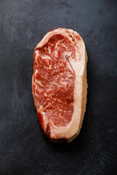 Raw Black Angus Prime meat steak Striploin on dark background