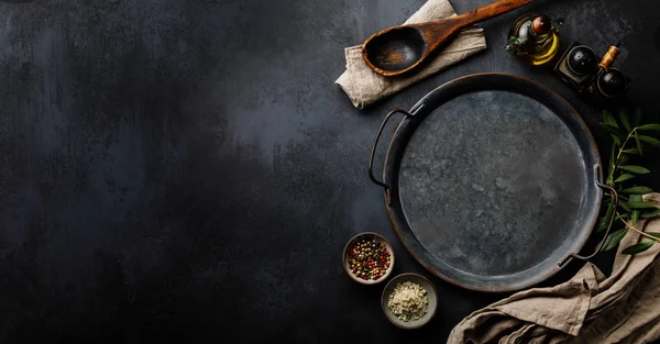 Round metal Tray and Spices on dark concrete backdrop Surface copy space for design text