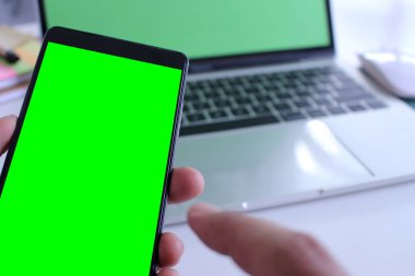 yeşil ekran smartphone noktası ile ofis resepsiyon masa arka planda tutan iş adamı