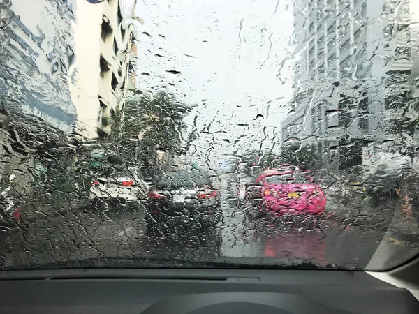 Road view through car window with rain drops, Driving in rain