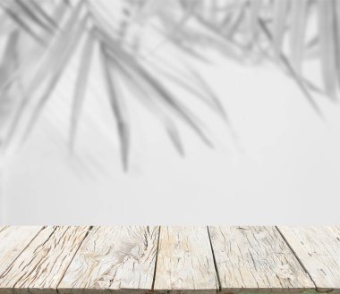 Palmiye yapraklarının ahşap zeminli bulanık gri gölge arkaplanı, siyah ve beyaz tek renk tonu 