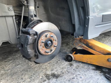 Jack Hidrolik tekerleksiz araba kaldırıyor ve yeni lastik değişimi için bekliyor.