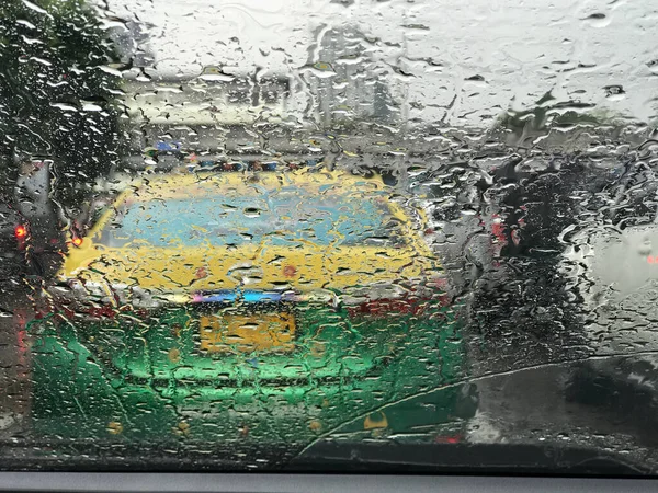 Road view through car window with rain drops, Driving in rain.